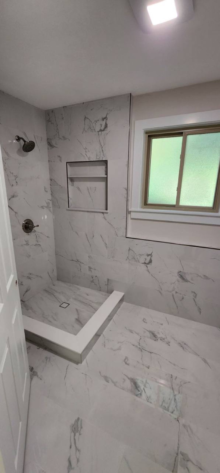 Marble walk-in shower with niche