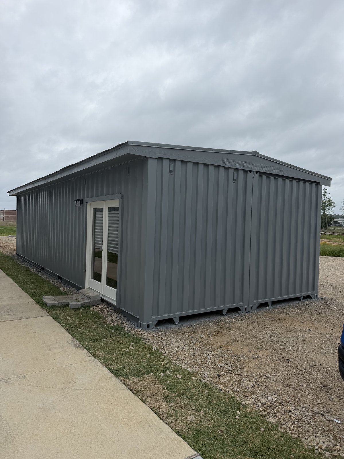 Shipping container after — finished metal roof, side panels installed