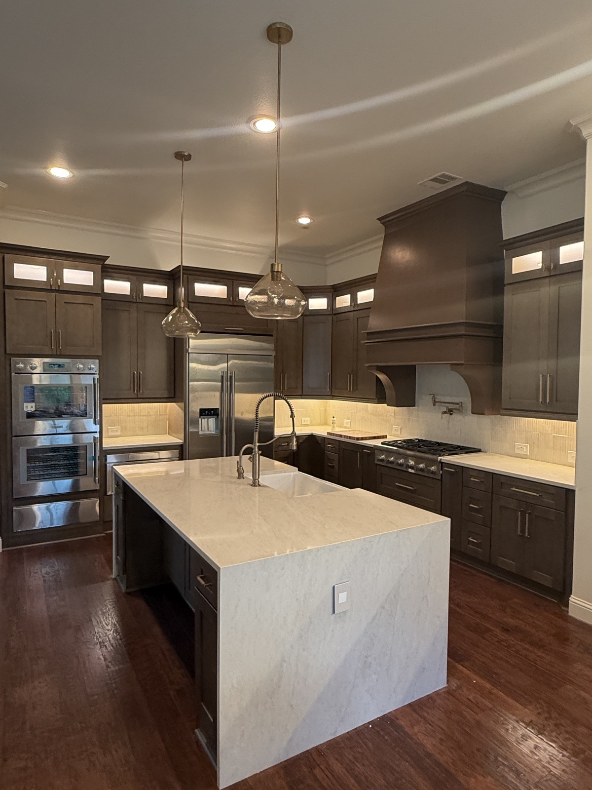 Completed kitchen remodel — waterfall island and custom hood, The Woodlands TX