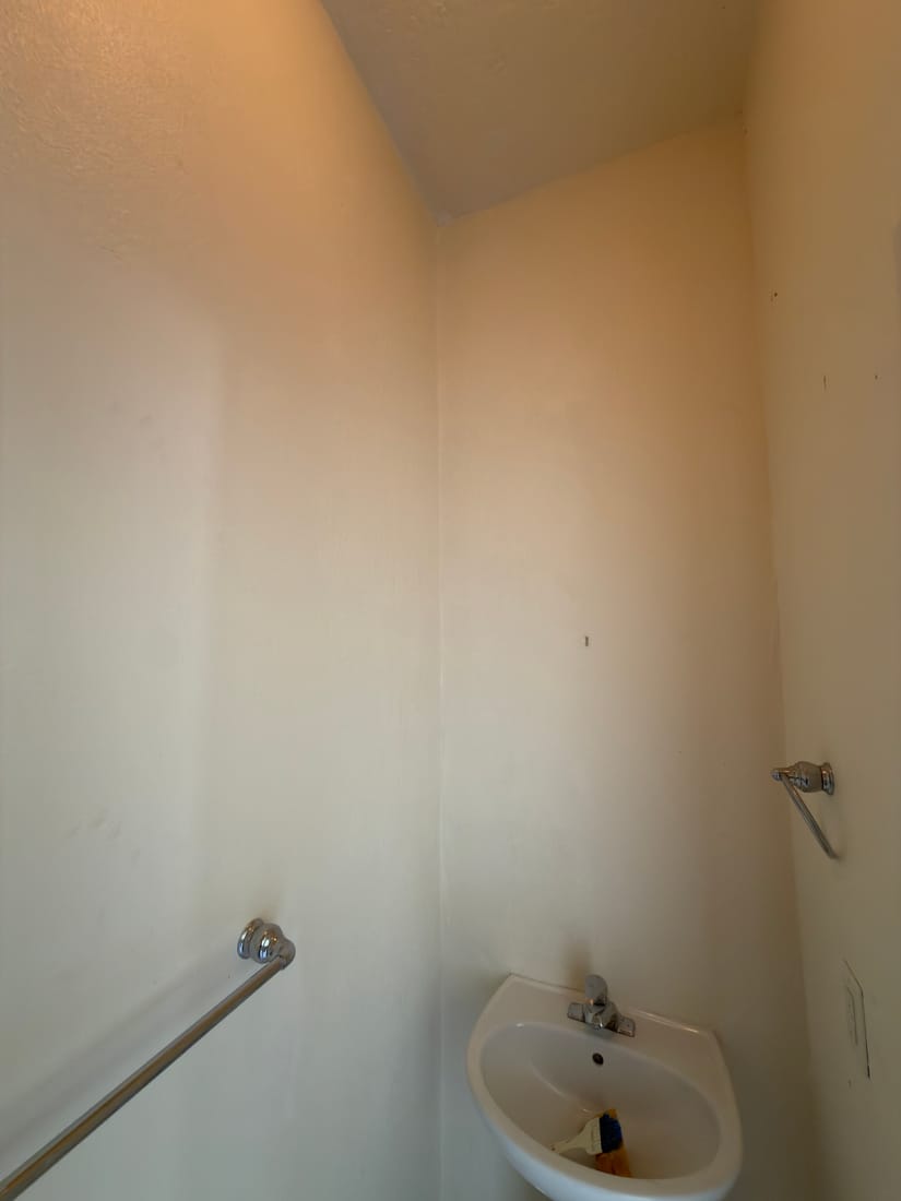 Powder room wall after — termite-damaged framing replaced, drywall textured and painted seamless